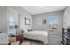 Comfortable bedroom with a soft white bed, a corner reading chair and dual light fixtures at 10643 E Tumbleweed Ave, Mesa, AZ 85212