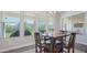 Bright dining area features a wooden table with four chairs, large windows, and views of the landscaped backyard at 10643 E Tumbleweed Ave, Mesa, AZ 85212