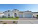 Inviting single-story home featuring a three-car garage, desert landscaping, and a brick-paved driveway at 10643 E Tumbleweed Ave, Mesa, AZ 85212