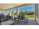 Inviting covered patio with comfortable seating and a view of the manicured backyard at 10643 E Tumbleweed Ave, Mesa, AZ 85212