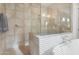 Tiled walk-in shower next to the large soaking tub with large tiling and glass door at 10643 E Tumbleweed Ave, Mesa, AZ 85212