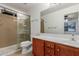 This bathroom features a glass shower, vanity with sink, and wooden cabinets for a spa-like experience at 12132 W Caribbean Ln, El Mirage, AZ 85335