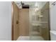Bathroom shower featuring glass door, shower head and tan-colored shower enclosure at 12132 W Caribbean Ln, El Mirage, AZ 85335