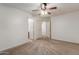 This bedroom features carpet, a ceiling fan, and multiple doorways for easy access throughout the home at 12132 W Caribbean Ln, El Mirage, AZ 85335