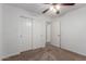 Bedroom with carpet, ceiling fan and white closet doors at 12132 W Caribbean Ln, El Mirage, AZ 85335