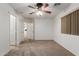 This bedroom has carpet, a ceiling fan, and two doorways for seamless navigation throughout the home at 12132 W Caribbean Ln, El Mirage, AZ 85335