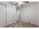 Bedroom featuring carpet, ceiling fan and white closet doors at 12132 W Caribbean Ln, El Mirage, AZ 85335