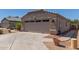Beige home with two-car garage and desert landscaping, showcasing ample parking at 12132 W Caribbean Ln, El Mirage, AZ 85335