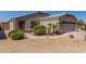 Tan home with two-car garage, desert landscaping, and security gate at 12132 W Caribbean Ln, El Mirage, AZ 85335