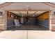 Open garage with shelving, cabinets, lighting and ceiling fan at 12132 W Caribbean Ln, El Mirage, AZ 85335