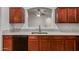 This kitchen features wooden cabinets, granite countertops, and modern appliances for a culinary experience at 12132 W Caribbean Ln, El Mirage, AZ 85335
