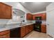 This kitchen has wooden cabinets, black appliances, and granite countertops for a modern touch at 12132 W Caribbean Ln, El Mirage, AZ 85335