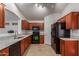 This kitchen has wooden cabinets, black appliances, and granite countertops for a modern touch at 12132 W Caribbean Ln, El Mirage, AZ 85335