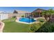 Backyard pool featuring a basketball hoop, putting green, and desert landscaping at 12132 W Caribbean Ln, El Mirage, AZ 85335