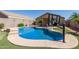 Backyard pool featuring basketball hoop, steps, and desert landscaping at 12132 W Caribbean Ln, El Mirage, AZ 85335