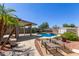 Backyard pool with covered patio and lounge chairs, surrounded by desert landscaping at 12132 W Caribbean Ln, El Mirage, AZ 85335
