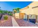 View of the backyard with path to a outdoor kitchen and nice landscaping at 13716 W Nogales Dr, Sun City West, AZ 85375