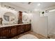 Bathroom with double sink vanity, granite countertop, wood cabinets, and walk in shower at 13716 W Nogales Dr, Sun City West, AZ 85375
