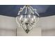 Stylish chandelier with decorative metalwork and candle-style lights against a blue ceiling at 13716 W Nogales Dr, Sun City West, AZ 85375