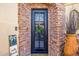 Elegant black front door framed by stone accents, leading to a welcoming home at 13716 W Nogales Dr, Sun City West, AZ 85375