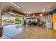Spacious garage with epoxy flooring, golf cart, and ample storage space with an open garage door at 13716 W Nogales Dr, Sun City West, AZ 85375