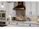 Kitchen with custom cabinetry, gas range, stylish backsplash, and stainless appliances at 13716 W Nogales Dr, Sun City West, AZ 85375