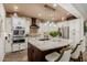Gourmet kitchen featuring white cabinets, stainless steel appliances, and a large granite island at 13716 W Nogales Dr, Sun City West, AZ 85375
