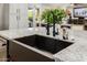 Close-up of the kitchen island with a deep sink, black faucet, and flowers at 13716 W Nogales Dr, Sun City West, AZ 85375