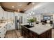 Open kitchen with stainless steel fridge, granite island, and seamless flow to the living area at 13716 W Nogales Dr, Sun City West, AZ 85375