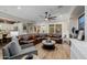 Spacious living room featuring a brown sectional sofa, round ottoman, and tasteful decorations at 13716 W Nogales Dr, Sun City West, AZ 85375