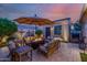 Cozy outdoor patio featuring cushioned seating and a warm fire pit under an umbrella at 13716 W Nogales Dr, Sun City West, AZ 85375