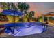 Beautiful backyard pool with illuminated landscaping and a cozy patio area at 13716 W Nogales Dr, Sun City West, AZ 85375