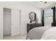 Bright bedroom featuring a dark wood dresser with a decorative mirror and a window with natural light at 15348 W Gray Fox Trl, Surprise, AZ 85387
