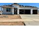 New construction featuring a three-car garage with contemporary design and desert landscaping at 15348 W Gray Fox Trl, Surprise, AZ 85387