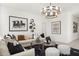 Bright living room with a neutral sectional, black and white accents, and modern artwork and mirrors at 15348 W Gray Fox Trl, Surprise, AZ 85387