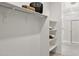 Walk-in closet includes open shelving and clear shower door entrance, optimizing space and organization at 15348 W Gray Fox Trl, Surprise, AZ 85387