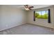 Cozy bedroom featuring a ceiling fan and window offering serene views of lush greenery at 18207 N 46Th St, Phoenix, AZ 85032