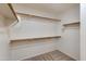 Spacious walk-in closet with multiple levels of shelving and wood closet rods for optimal storage solutions at 18207 N 46Th St, Phoenix, AZ 85032