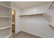 Well-organized walk-in closet featuring built-in shelving and a view of the ensuite bathroom at 18207 N 46Th St, Phoenix, AZ 85032