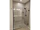 Glass enclosed shower with contemporary fixtures and tiled walls, reflecting the double sink vanity at 18871 S 209Th Way, Queen Creek, AZ 85142
