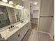 Modern bathroom featuring double sinks, white cabinetry, and a walk-in shower, adjacent to a walk-in closet at 18871 S 209Th Way, Queen Creek, AZ 85142