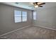 Spacious bedroom with neutral carpeting, ceiling fan, and multiple windows for ample natural light at 18871 S 209Th Way, Queen Creek, AZ 85142
