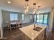 Bright living room with wood floors, an adjacent dining area, and a view of the backyard at 18871 S 209Th Way, Queen Creek, AZ 85142