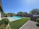 Sparkling pool with artificial turf, desert landscaping and privacy wall in a sunny backyard at 18871 S 209Th Way, Queen Creek, AZ 85142