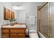 Cozy bathroom with wood vanity, tiled floors, vanity and shower with glass doors at 1905 N Calle Maderas --, Mesa, AZ 85213
