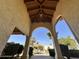 Charming front entrance framed by archways and lush greenery, leading to the home's facade at 1905 N Calle Maderas --, Mesa, AZ 85213