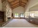 Spacious living room with a stone fireplace, beamed ceilings, built-in bookshelves, and backyard access at 1905 N Calle Maderas --, Mesa, AZ 85213
