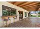 Covered patio with a serving bar, terracotta-tiled floor, exposed beams and large windows at 1905 N Calle Maderas --, Mesa, AZ 85213
