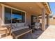 Covered back porch with comfortable seating, coffee table, and tile floors at 19771 W Woodlands Ave, Buckeye, AZ 85326