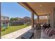 Inviting backyard with a covered patio, artificial grass, above-ground pool, and ample seating areas at 19771 W Woodlands Ave, Buckeye, AZ 85326